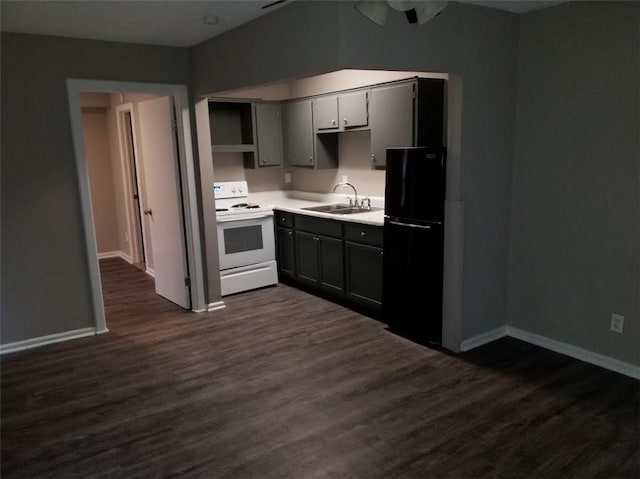 kitchen with gray cabinetry, sink, white range oven, dark wood-type flooring, and black fridge