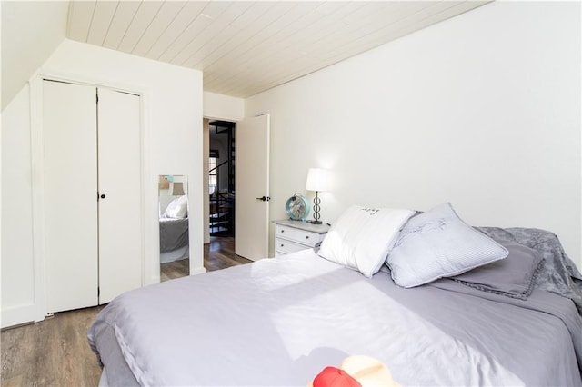 bedroom with light hardwood / wood-style floors, a closet, and wooden ceiling