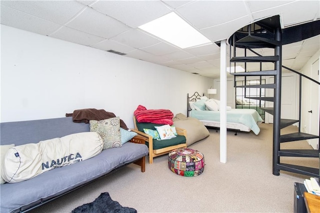 bedroom with carpet flooring and a drop ceiling