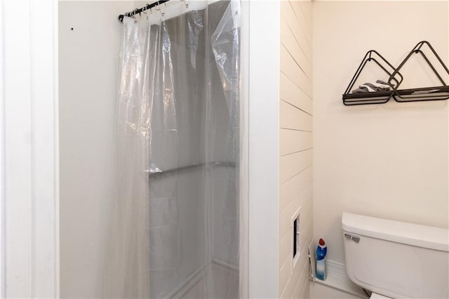 bathroom with curtained shower and toilet