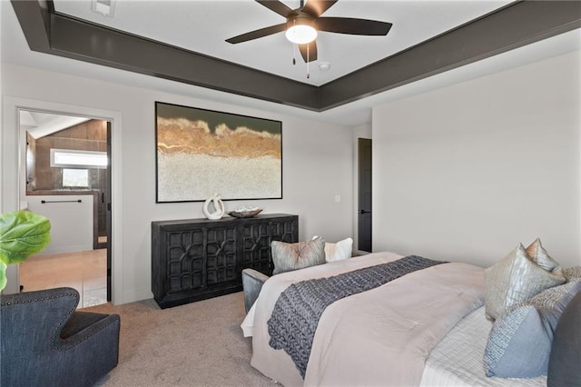 bedroom with light colored carpet, ceiling fan, and a raised ceiling