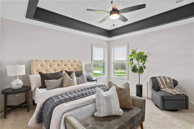 bedroom featuring ceiling fan, carpet, and a tray ceiling