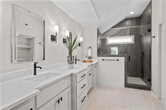 bathroom with a shower with shower door, tile flooring, vanity, and lofted ceiling