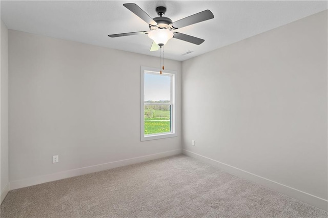 carpeted spare room featuring ceiling fan