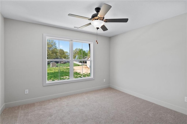 carpeted empty room featuring a wealth of natural light and ceiling fan