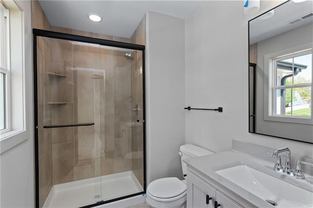 bathroom with walk in shower, vanity, and toilet