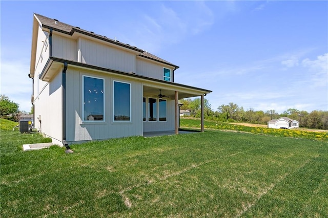 rear view of property with central AC and a lawn