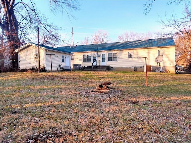 rear view of property featuring a lawn