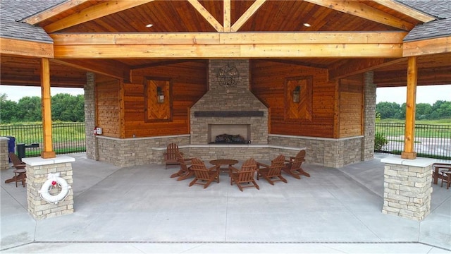 view of patio with a gazebo and an outdoor stone fireplace