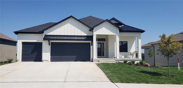 modern farmhouse featuring a garage, a porch, and a front yard