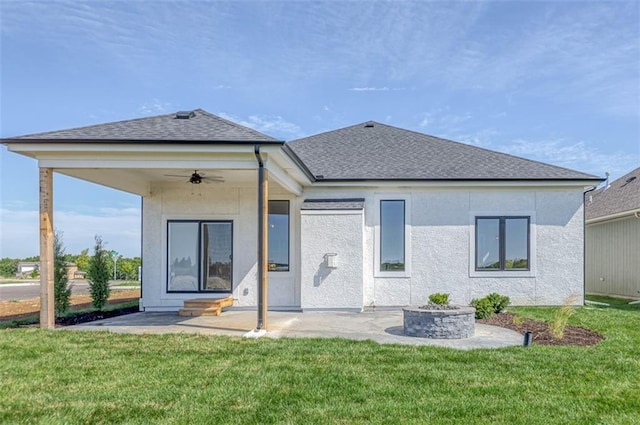 rear view of property featuring a lawn, ceiling fan, and a patio area