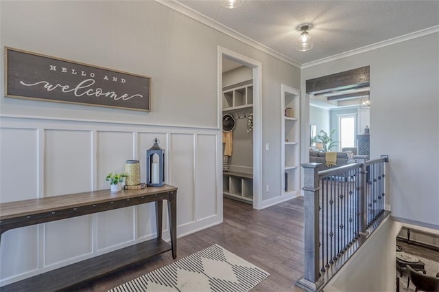 interior space with built in shelves, crown molding, dark wood-type flooring, and a textured ceiling