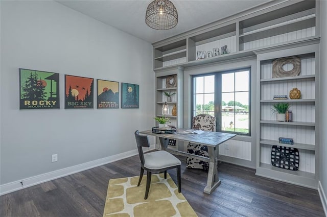 home office featuring dark hardwood / wood-style floors and built in shelves