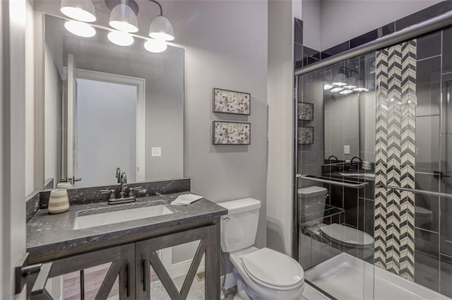 bathroom with vanity, toilet, and walk in shower