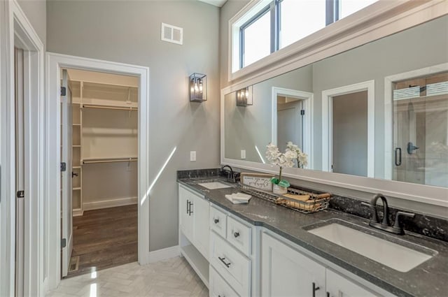 bathroom featuring vanity and a shower with door