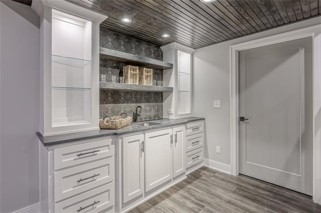 bar with wooden ceiling, sink, hardwood / wood-style flooring, decorative backsplash, and white cabinetry