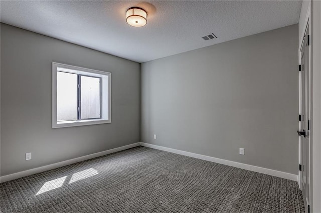 unfurnished room with carpet floors and a textured ceiling