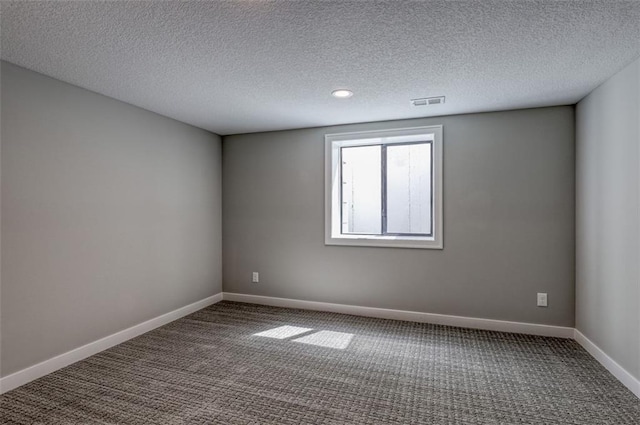 carpeted empty room with a textured ceiling