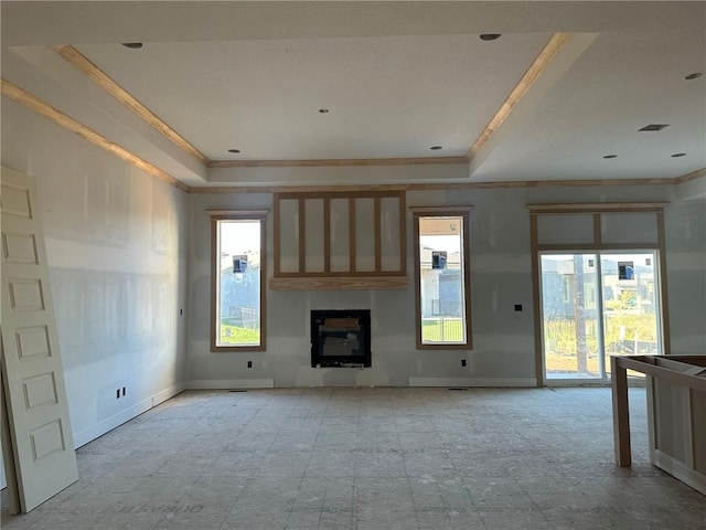 unfurnished living room with a tray ceiling and ornamental molding