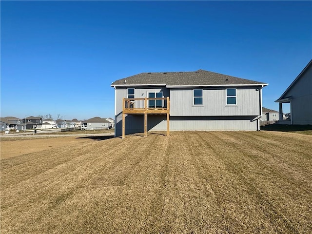 rear view of property featuring a lawn and a wooden deck