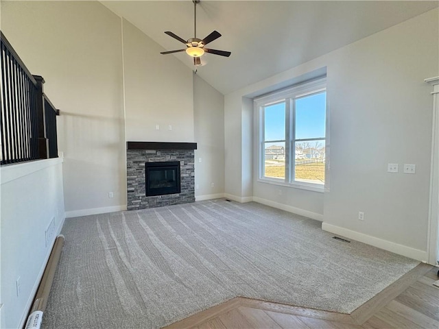 unfurnished living room with light carpet, baseboard heating, ceiling fan, high vaulted ceiling, and a stone fireplace