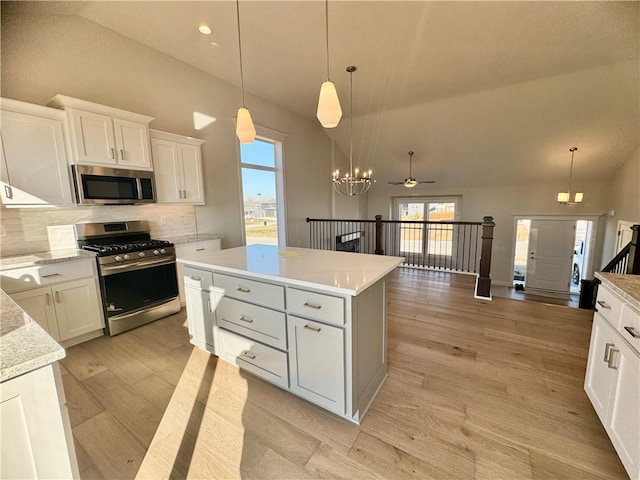 kitchen with white cabinets, stainless steel appliances, hanging light fixtures, and ceiling fan