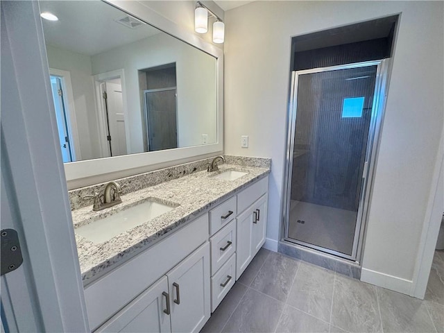 bathroom featuring a shower with door and vanity