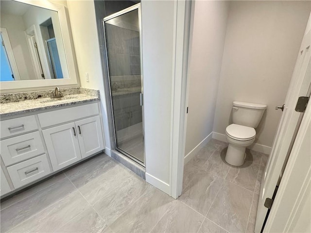 bathroom with vanity, toilet, and a shower with door