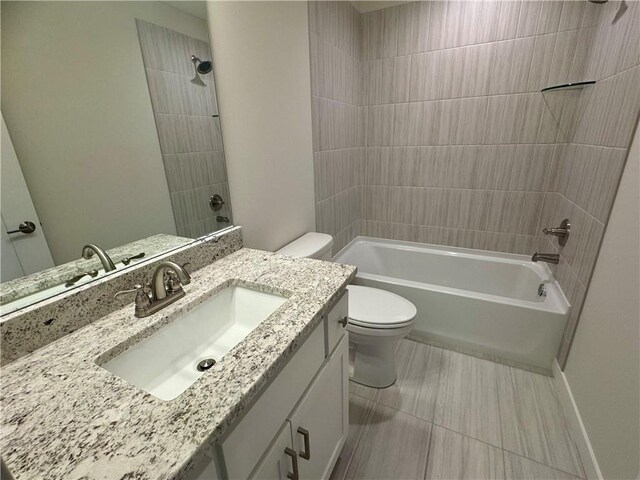 full bathroom featuring tiled shower / bath, vanity, and toilet