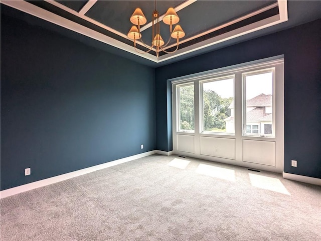 spare room with a notable chandelier, carpet, and a tray ceiling