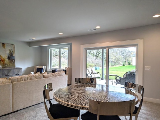 carpeted dining room with a wealth of natural light