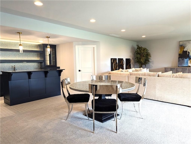 carpeted dining space featuring bar