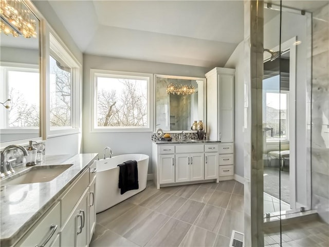 bathroom featuring vanity, a notable chandelier, tile patterned floors, and a bathtub