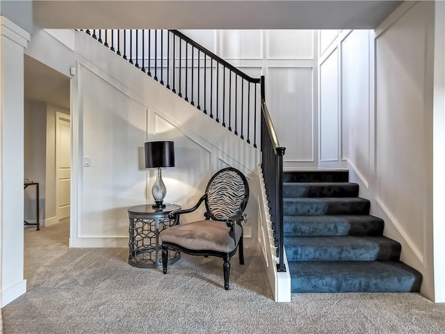 staircase featuring carpet