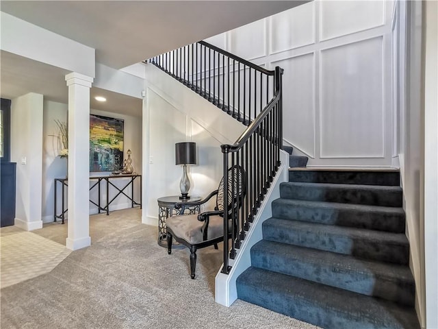 stairway with carpet and ornate columns