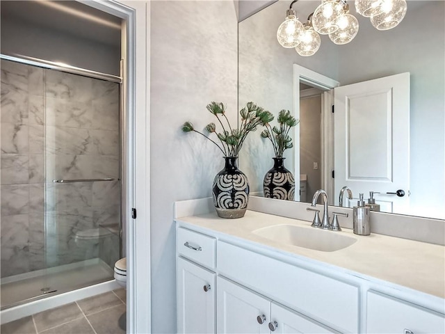 bathroom with a shower with door, vanity, toilet, and tile patterned floors