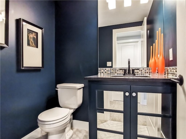 bathroom with vanity, toilet, and backsplash