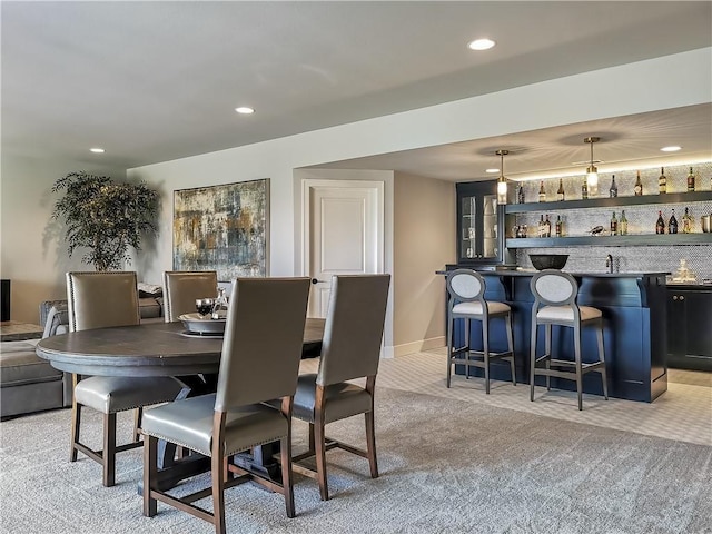 carpeted dining area with bar area