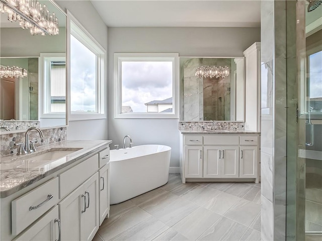 9301 W 168th St, Overland Park, KS 66085 - full bathroom featuring a chandelier, two vanities, a stall shower, and a freestanding bath