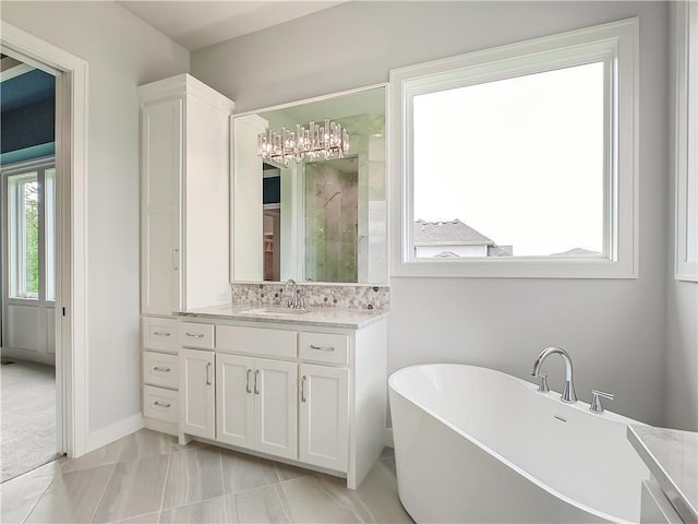 9301 W 168th St, Overland Park, KS 66085 - full bathroom with vanity, a freestanding tub, a chandelier, a stall shower, and baseboards