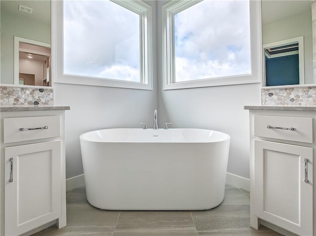 9301 W 168th St, Overland Park, KS 66085 - bathroom with decorative backsplash, vanity, and a freestanding tub