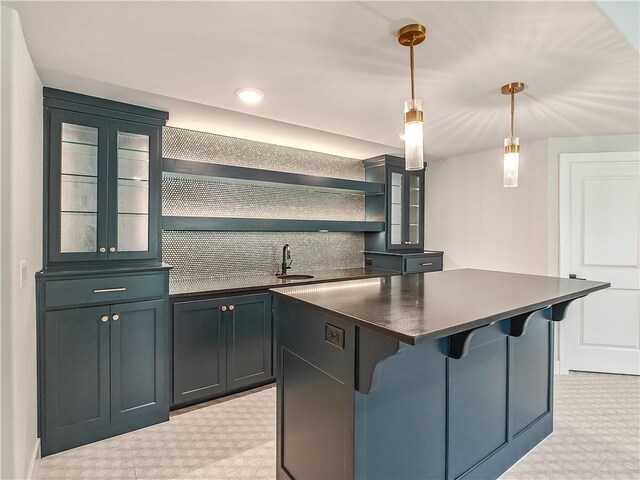 9301 W 168th St, Overland Park, KS 66085 - kitchen with dark countertops, light flooring, a center island, a sink, and a kitchen breakfast bar