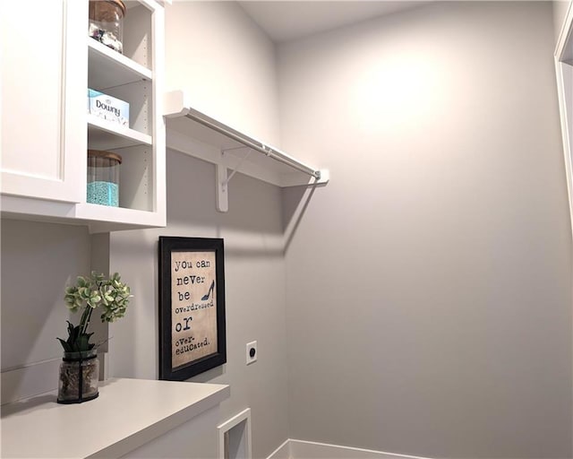 clothes washing area featuring hookup for an electric dryer and cabinets