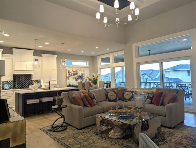 living room with light hardwood / wood-style floors and a notable chandelier