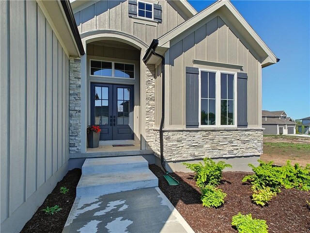 16724 Hayes St, Overland Park, KS 66085 - entrance to property with stone siding, french doors, and board and batten siding