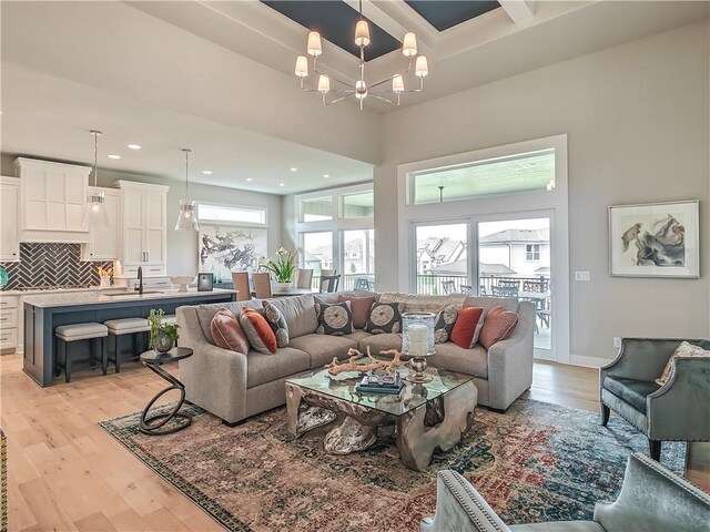 16724 Hayes St, Overland Park, KS 66085 - living area featuring light wood-style flooring, a chandelier, recessed lighting, beam ceiling, and coffered ceiling
