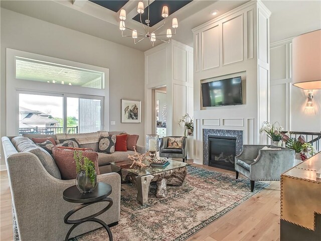 16724 Hayes St, Overland Park, KS 66085 - living room with light wood finished floors, a high end fireplace, a chandelier, and a decorative wall