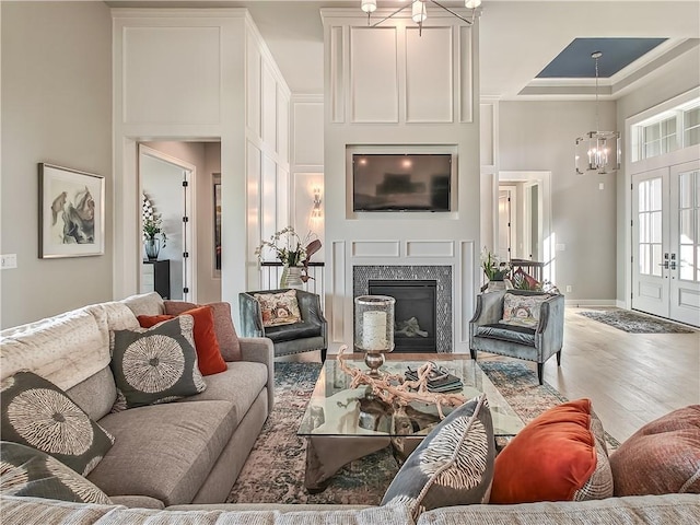16724 Hayes St, Overland Park, KS 66085 - living room featuring a chandelier, wood finished floors, a high ceiling, and a high end fireplace