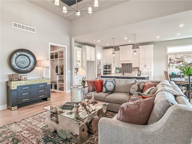 16724 Hayes St, Overland Park, KS 66085 - living room featuring a chandelier, light wood-style floors, baseboards, and recessed lighting