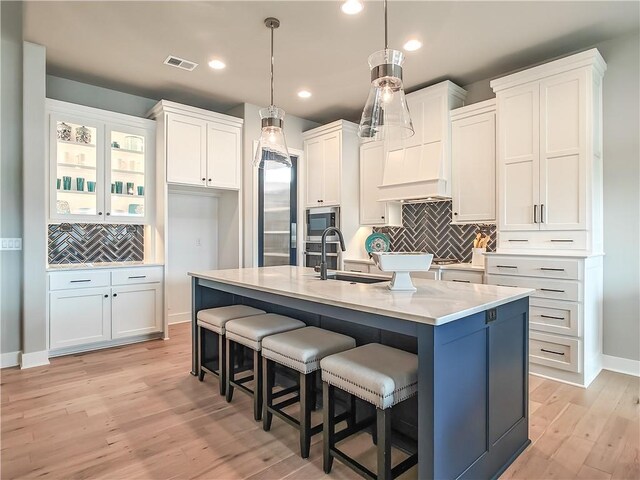 16724 Hayes St, Overland Park, KS 66085 - kitchen with built in appliances, a sink, white cabinets, light wood finished floors, and recessed lighting